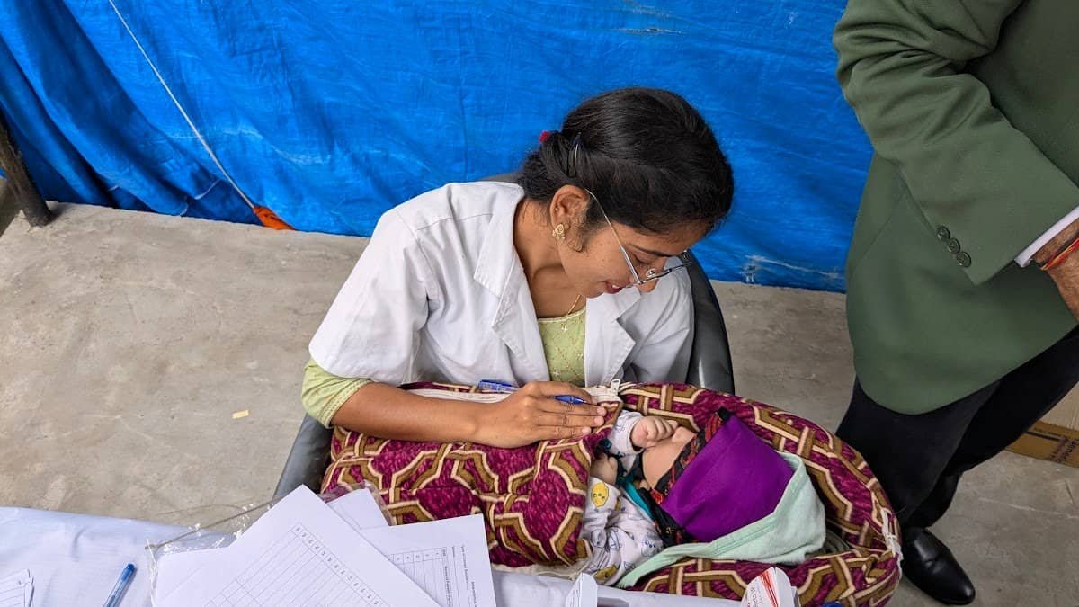 A doctor examining a child at a camp